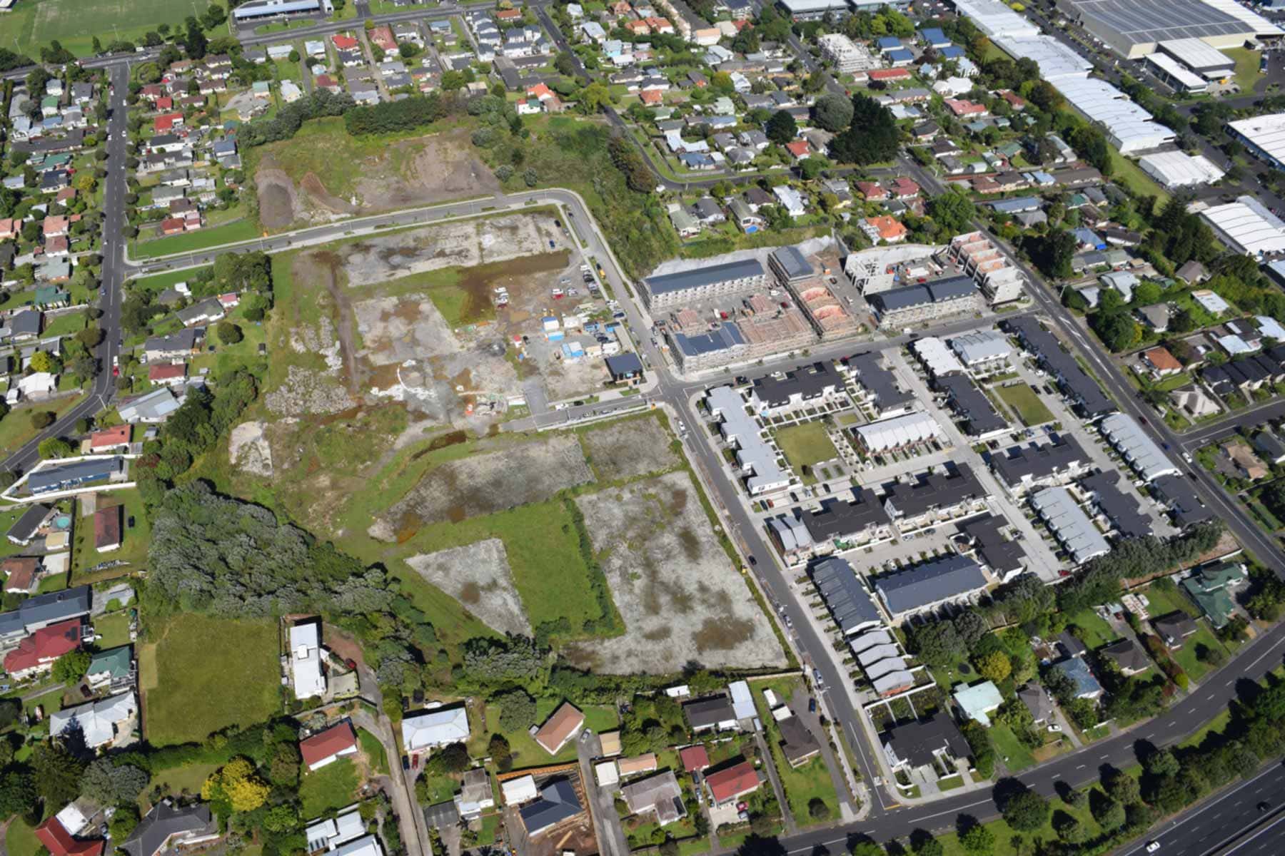Aerial view of the former Te Apunga-o-Tainui / McLennan Hills site, showing cleared land and new housing surrounded by Auckland suburbs.