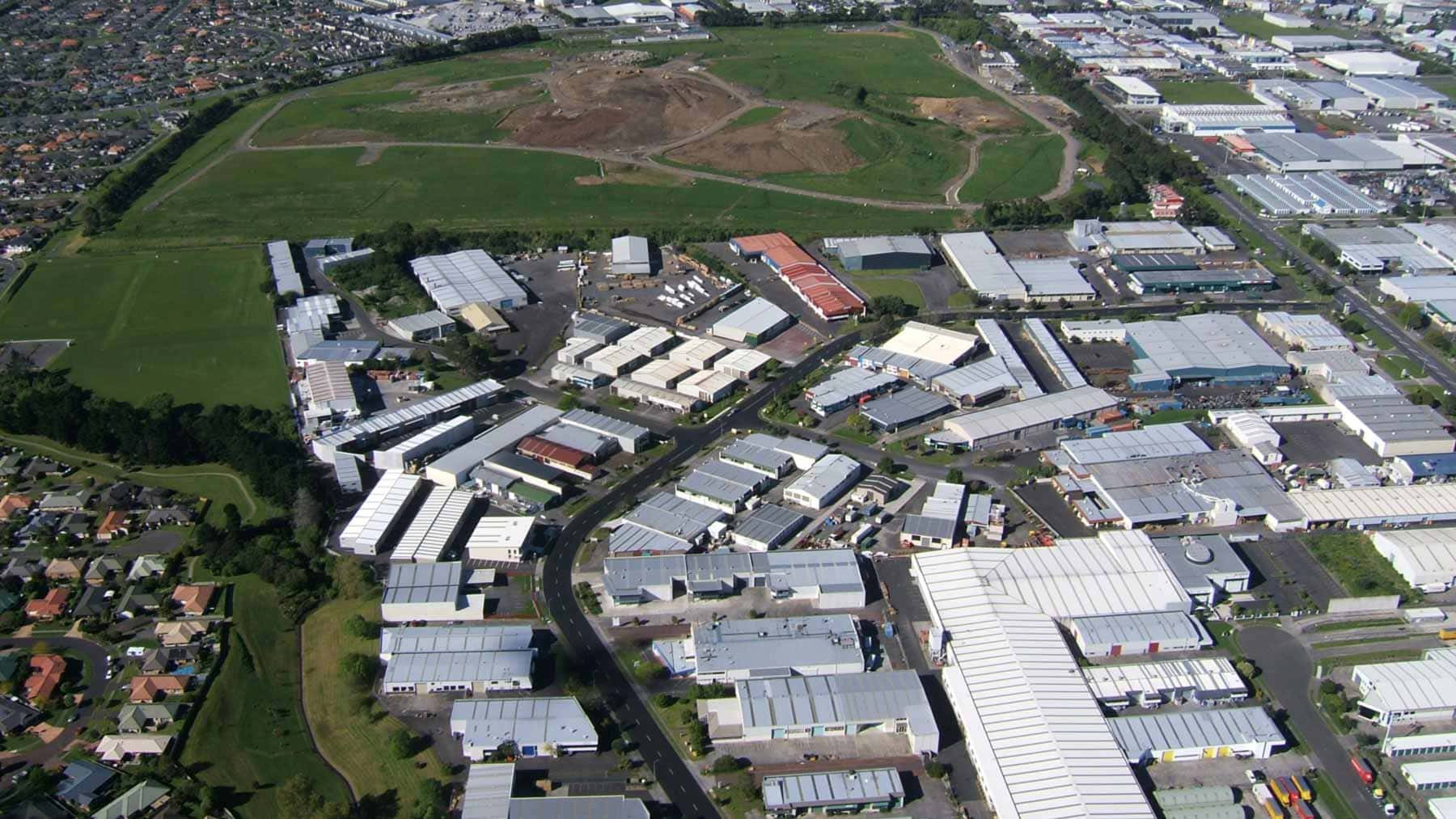 Aerial view of the industrial area covering Styaks Swamp Crater, with grassy land and surrounding suburbs.