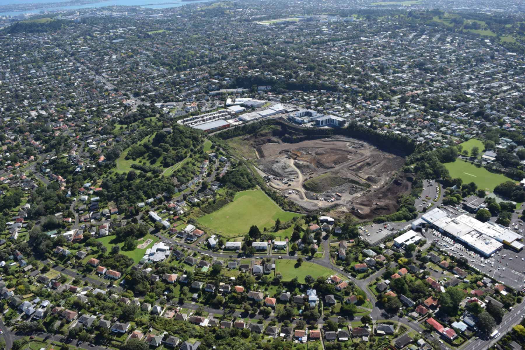 Aerial view of Three Kings, showing the remaining volcanic cone, former quarry and surrounding Auckland suburbs.