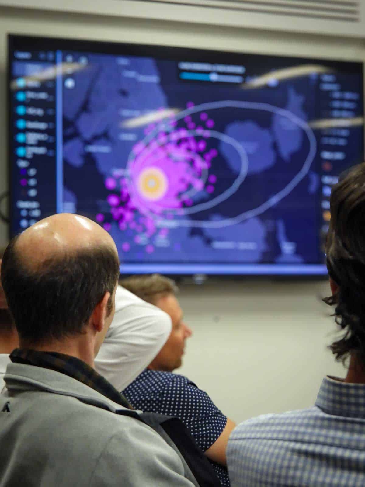 Workshop participants viewing a volcanic hazard map on a screen.
