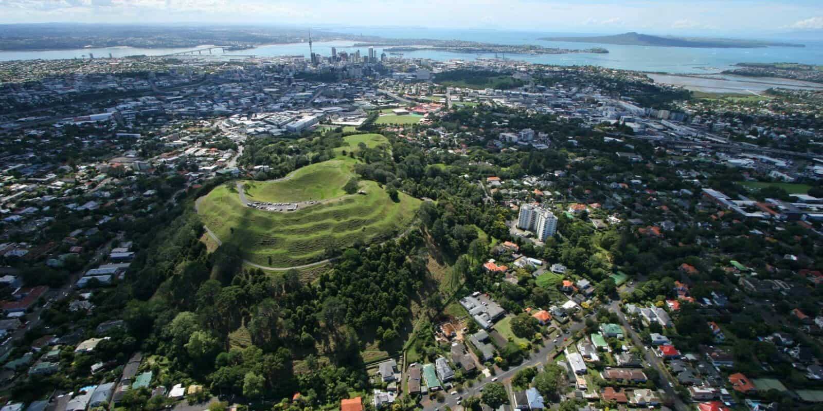 Aerial view of Maungawhau / Mt Eden and its crater, with the city behind