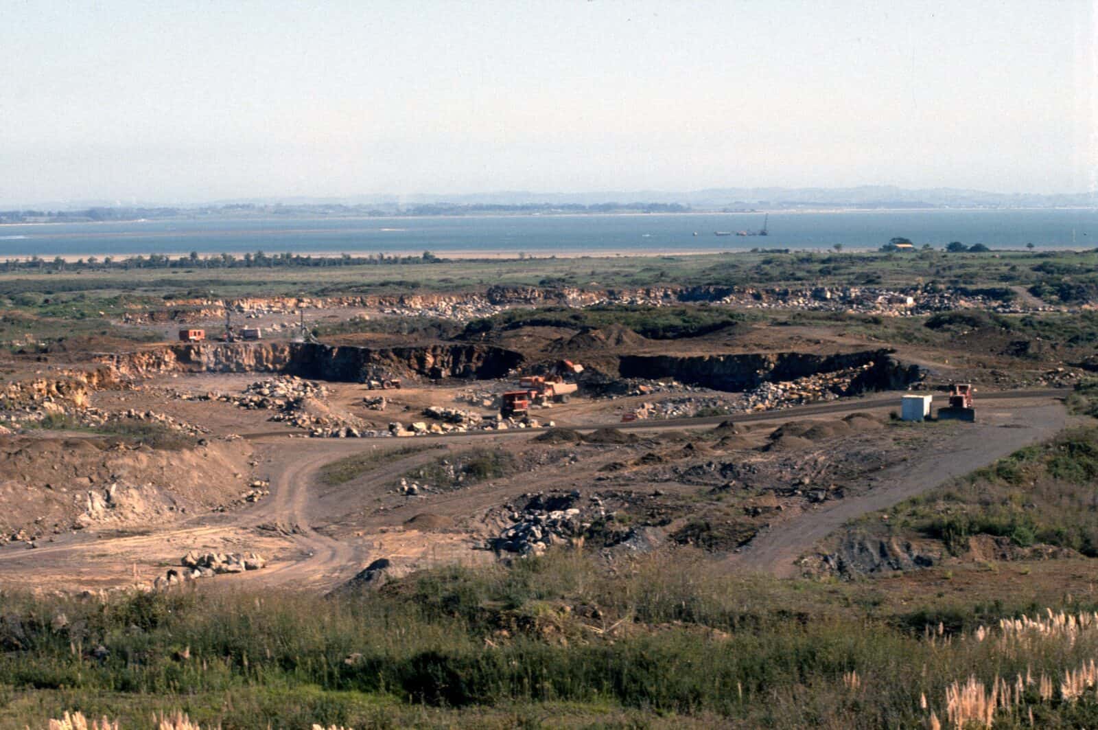 A quarry cut deep into the Wiri lava flow, its benches of bare rock stretching towards the harbour